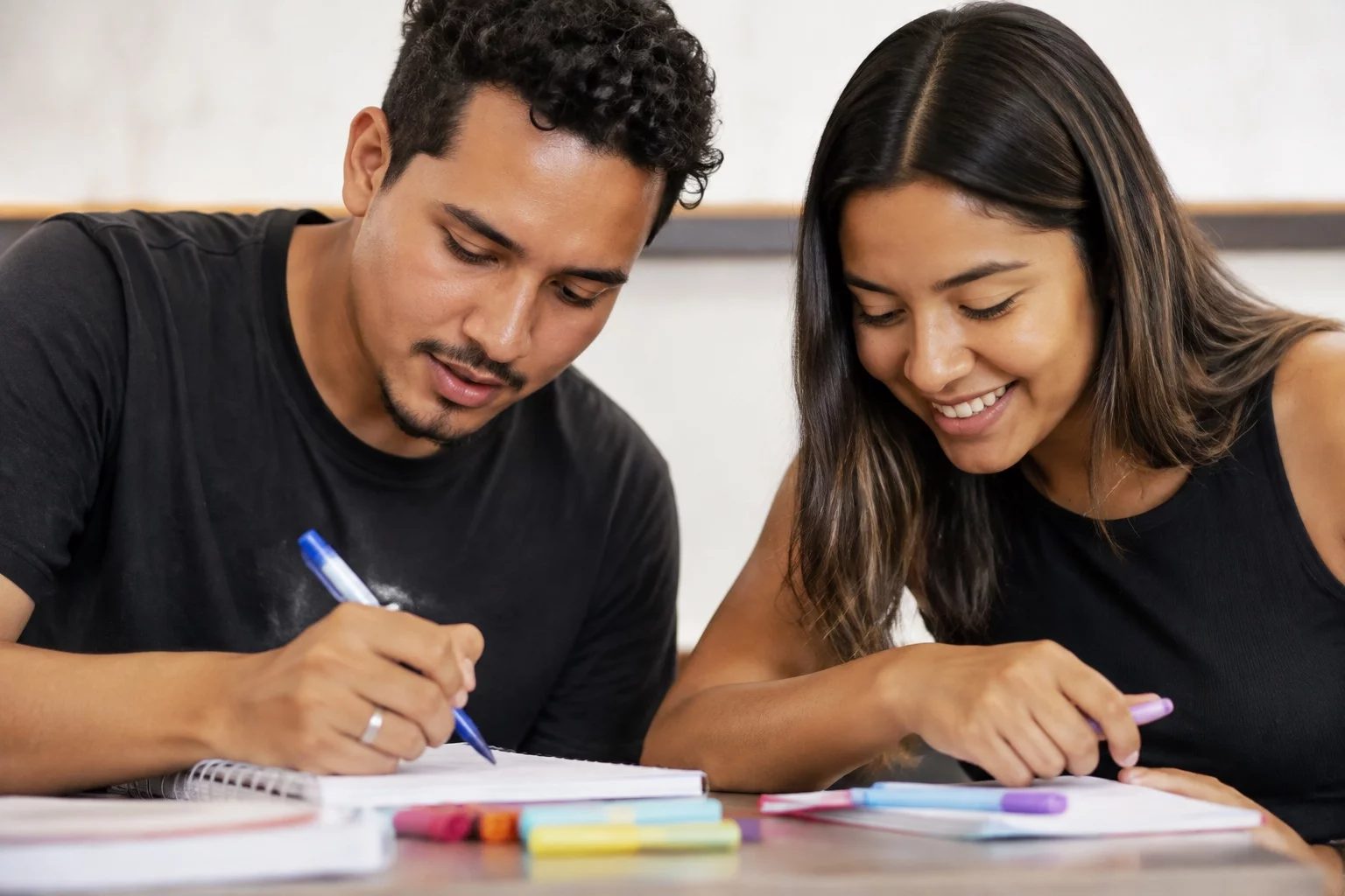 Dois estudantes preparando um debate com cadernos e marcadores